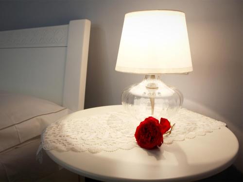 a red rose on a table with a lamp at Bed And Breakfast 22 Garibaldi Home in Riccione