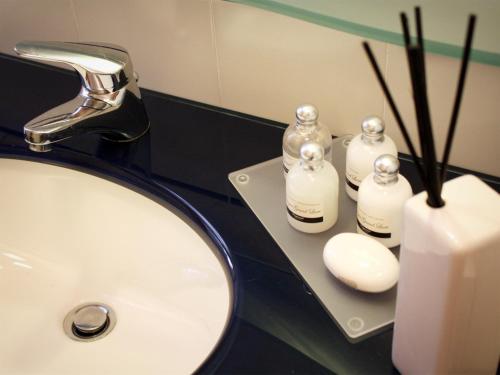 a bathroom sink with two bottles of soap and a candle at Bed And Breakfast 22 Garibaldi Home in Riccione