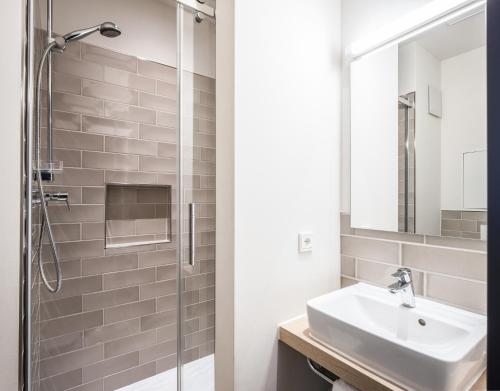 a bathroom with a sink and a shower at HUB Apartments in Hamburg