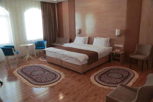 a hotel room with a large bed and chairs at Hotel Uzbekistan in Urganch