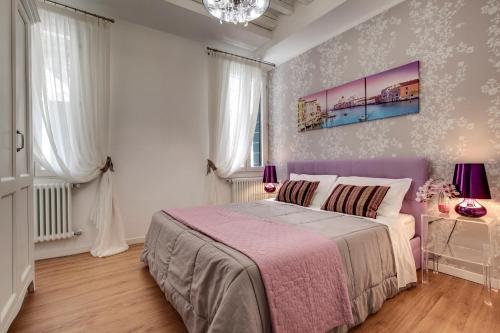 a bedroom with a large bed with a pink blanket at Charming Castello Apartments in Venice