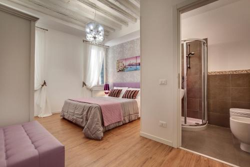 1 dormitorio con 1 cama y baño con lavamanos en Charming Castello Apartments, en Venecia