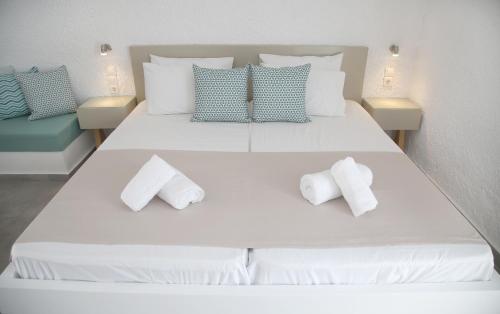 a large white bed with two pillows on it at Blue Ocean Apartments in Makry Gialos