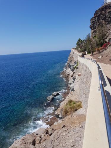 a road next to the ocean on a cliff at APT with terrace facing Amadores beach in Amadores