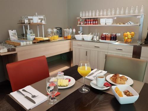 una mesa con dos platos de comida y vasos de zumo de naranja en Hotel de la Source, en Francorchamps