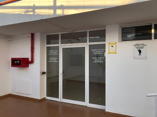 a glass door in a building with a sign on it at APT with terrace facing Amadores beach in Amadores