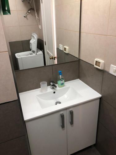 a bathroom with a white sink and a mirror at APT with terrace facing Amadores beach in Amadores