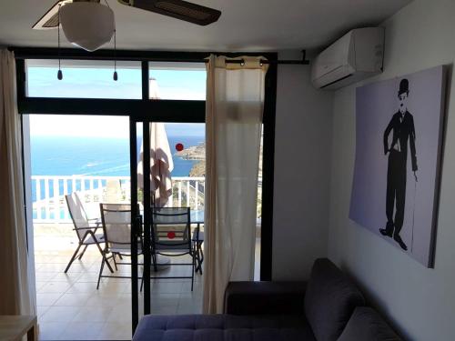 a living room with a couch and a view of the ocean at APT with terrace facing Amadores beach in Amadores