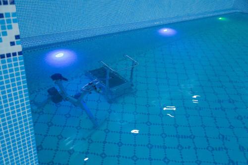 a person in the water in a swimming pool at Hotel Uzbekistan in Urganch