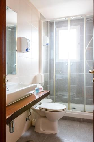 a bathroom with a toilet and a tub and a shower at Hotel Mavi in La Cabrera