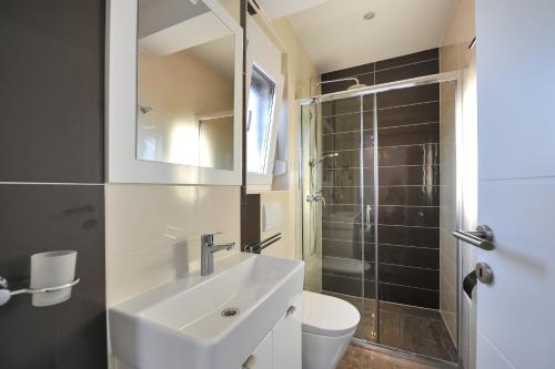 ein Badezimmer mit Waschbecken, Toilette und Dusche in der Unterkunft Villa Lily ZadarVillas in Privlaka