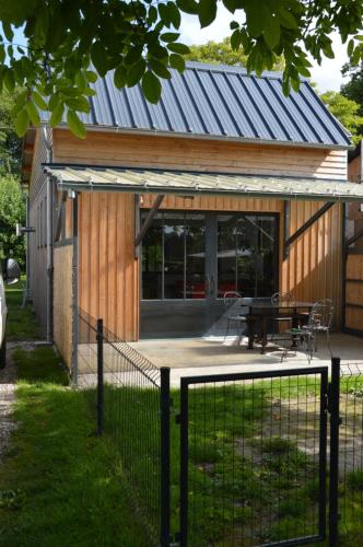a house with a metal roof and a patio at LA MENUISERIE D'ANDRE in Gueures