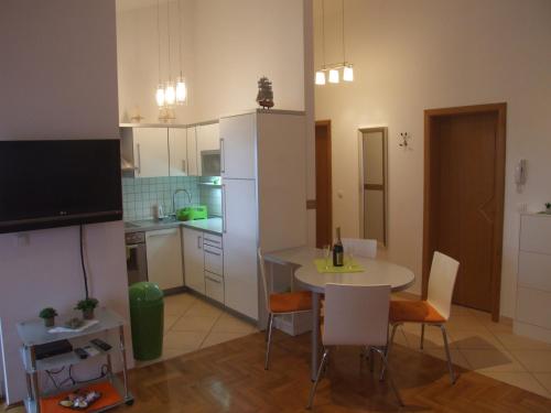 a kitchen and dining room with a table and chairs at Apartman Helen in Malinska