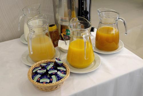 three jars of orange juice and a basket of oreos at Vácz Hotel in Vác