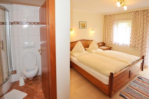 ein Schlafzimmer mit einem Bett und ein Badezimmer mit einer Dusche in der Unterkunft Feichtlehnerhof in Ramsau am Dachstein
