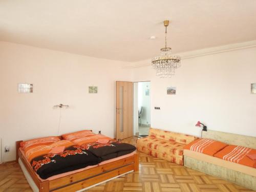 a bedroom with two beds and a chandelier at Apartmán Modré z nebe in Němčičky