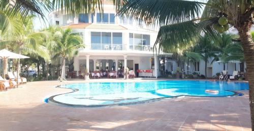 a swimming pool in front of a house at Muine Pacific Resort in Mui Ne