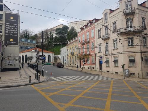 an empty street in a city with buildings at República Guest House in Coimbra