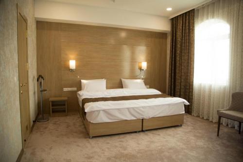 a bedroom with a large bed and a window at Hotel Uzbekistan in Urganch