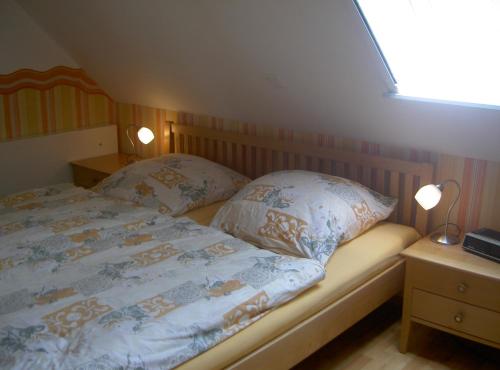 a bedroom with a bed with two pillows on it at Ferienwohnung Vieth in Filsum