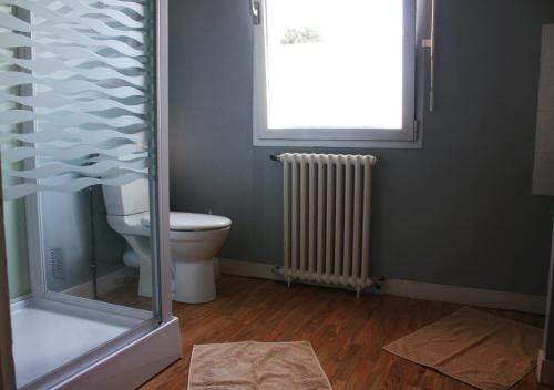 a bathroom with a toilet and a window at Pension de Kerioual in Roscoff