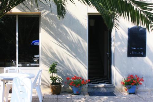a white building with a table and chairs and plants at Pension de Kerioual in Roscoff