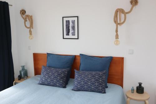 een slaapkamer met een bed met blauwe kussens bij Lagos Beach 59A in Lagos