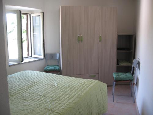 a bedroom with a bed and a cabinet and a window at Zephyros - VIVERE IL MARE E LA STORIA DEL BORGO in Santa Caterina dello Ionio