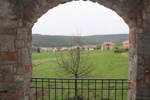 a view of a field through a stone window at Magtár Vendégház Harsány in Harsány