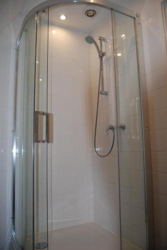 een badkamer met een douche en een glazen deur bij Bed&Brood De StraVerdonk in Graft
