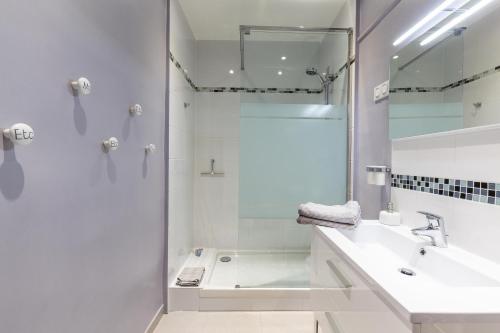 une salle de bain blanche avec une douche et un lavabo dans l'établissement La Dolce Vita - T3 Les Réformés, à Marseille