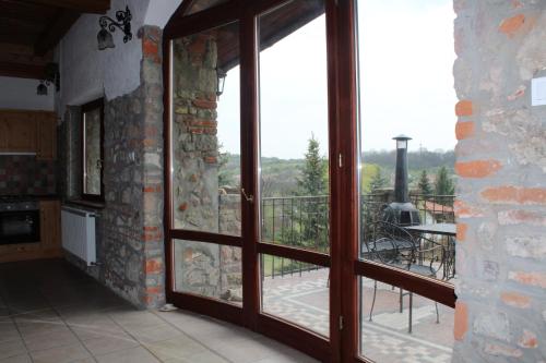a kitchen with a large glass door with a balcony at Magtár Vendégház Harsány in Harsány