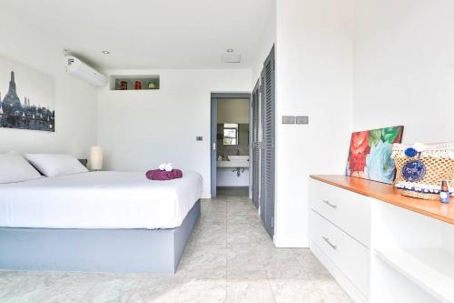 a white bedroom with a bed and a bathroom at Villa Hayou, Lamai Koh Samui in Lamai