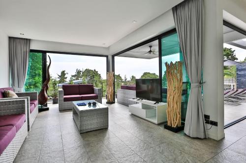a living room with a couch and a tv at Villa Hayou, Lamai Koh Samui in Lamai