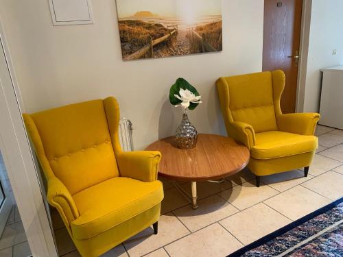 two yellow chairs and a table in a room at Tennis- und Freizeitzentrum Neudörfl in Neudörfl