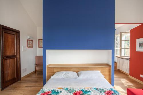 a bedroom with a blue wall and a bed at AMERICA NEI BOSCHI B&B in Bra