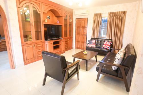 uma sala de estar com um sofá, uma mesa e cadeiras em Marin House Pattaya em Pattaya North