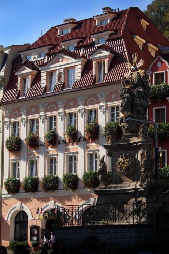 a large building with a fountain in front of it at Promenáda Romantic Hotel in Karlovy Vary