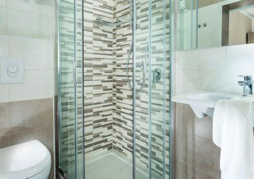 a bathroom with a shower and a toilet and a sink at Hotel Sammaritani in Rimini