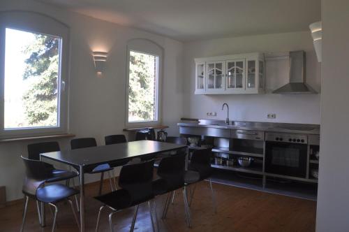 a kitchen with a table and chairs and a sink at Ferienhaus Ilse-Bilse in Neuhausen