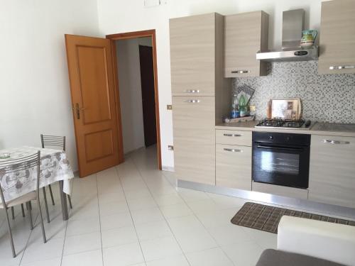 a kitchen with a stove and a table and a door at VILLA ELENA in Vico Equense