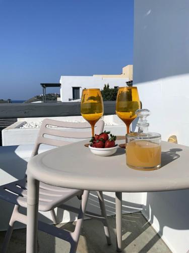 a table with two glasses of wine and a bowl of fruit at Aqua Blue, only 100 meters from the beach of Gialiskari in Ioulida
