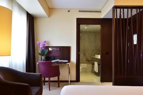 a hotel room with a desk and a room at Porto Palácio Hotel by The Editory in Porto