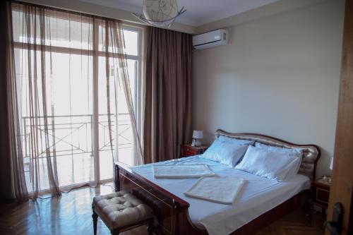 een slaapkamer met een bed en een groot raam bij Cozy Guest House in Old Batumi in Batoemi