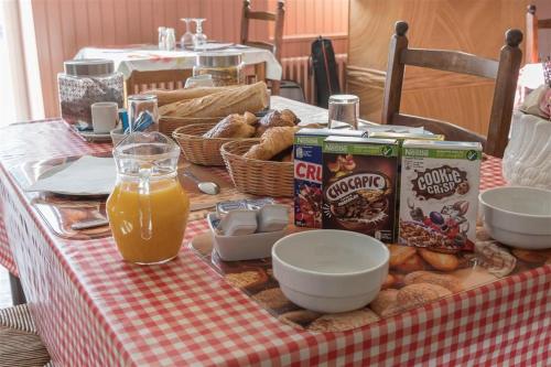 a table with a table cloth with food and orange juice at HOTEL DU CYGNE DE LA CROIX BLANCHE in Lailly-en-Val