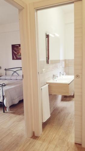 a bathroom with a sink and a bed with a mirror at Apartment Conchiglie in Cala Gonone