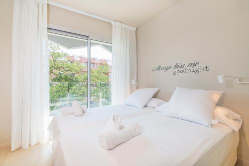 プラヤ・デアロにあるDaro Apartmentsの窓付きの客室で、白いベッド2台が備わります。