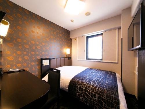 a hotel room with a bed and a table at APA Hotel Aomorieki-higashi in Aomori