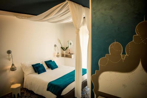 - une chambre avec un lit à baldaquin et des oreillers bleus dans l'établissement Mille una Notte, à Vasto