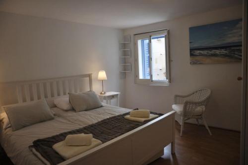 a bedroom with a bed with two pillows and a window at Apartment Gordana in Cres